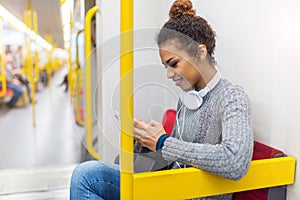 Young woman using mobile phone on subway