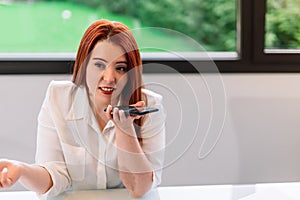 Young woman using mobile phone while working at home