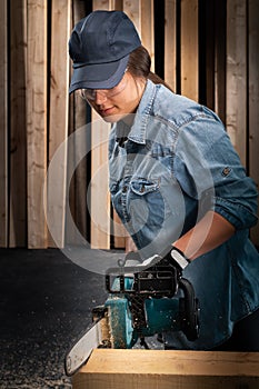 Young woman  using modern electric  saw in the workshop photo