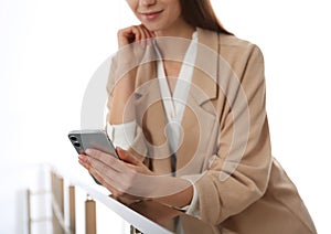 Young woman using modern smartphone indoors