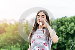 Young woman using nose spray for her pollen and grass allergies (Allergy relief). Spring Seasonal
