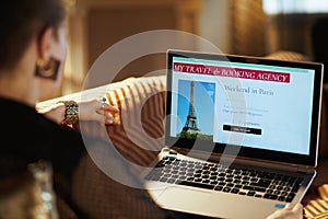 Young woman using online travel booking site on laptop