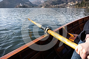 Young woman using paddle on a wooden boat - Lake Bled Slovenia rowing on wooden boats