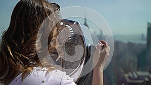 Young woman using scope at observation deck