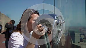 Young woman using scope at observation deck