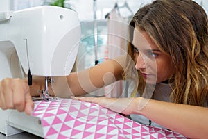 Young woman using sewing machine