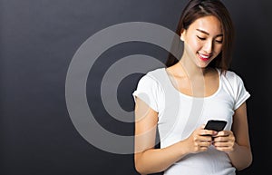 young woman using smart phone with black background