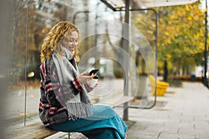 Young woman using smart phone at bus station