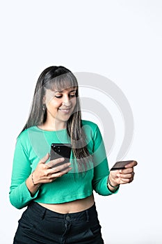 Young woman using smart phone and credit card on white background in studio. E-commerce and online shopping concept