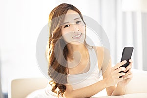 young woman using smart phone on sofa