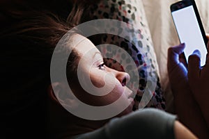 Young woman using smartphone in bed