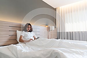 Young woman using smartphone on bed