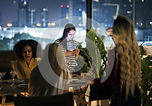 Young woman using a smartphone at a dinner night having no inter