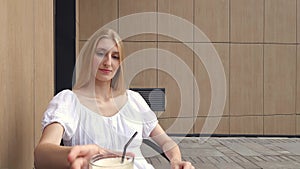 Young woman using smartphone and drinking raf coffee