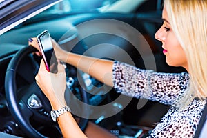 Young woman using a smartphone while driving a car