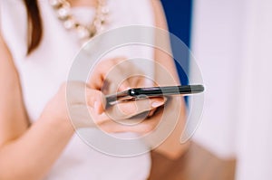 A young woman is using a smartphone indoor