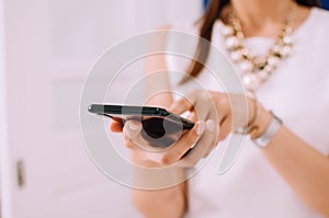 A young woman is using a smartphone indoor