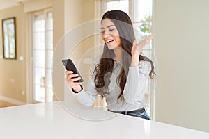 Young woman using smartphone sending a message very happy and excited, winner expression celebrating victory screaming with big