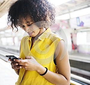 Young woman using a smartphone on the subway station