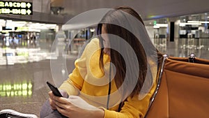 Young woman using smartphone in waiting room in airport