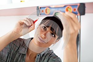 young woman using spirit level