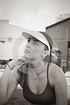 Young woman using sport wear with her hand under her chin in black and white. Artistic and sport concept