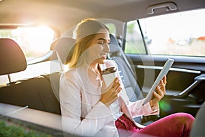 Young woman using a tablet in a car