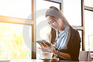 Young woman using tablet in coffee shop