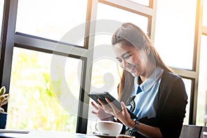 Young woman using tablet in coffee shop