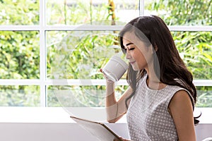 Young woman using tablet in coffee shop. Woman use mobile phone at coffee shop.