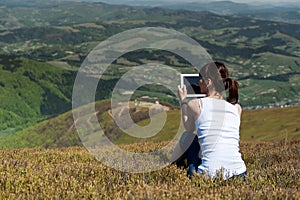 Young woman using tablet computer outdoors