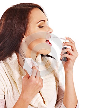 Young woman using throat spray.