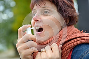 Young woman using throat spray