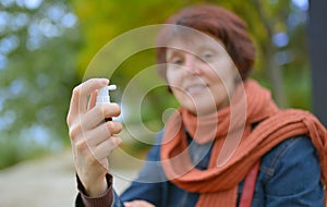 Young woman using throat spray