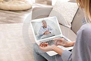 Young woman using video chat on laptop in living room