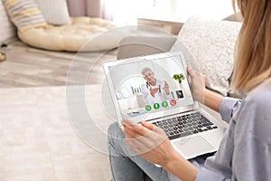 Young woman using video chat on laptop in living room
