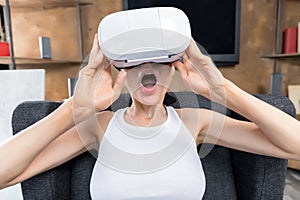 Young woman using virtual reality headset while sitting