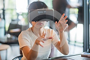 Young woman using virtual reality headset. VR, Future digital technology, game, entertainment, metaverse, NFT and 3D cyberspace