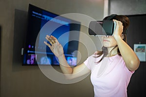 Young woman using virtual reality headset. VR, Future digital technology, game, movies entertainment, metaverse, NFT and 3D