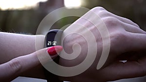 Young woman using wearable fitness tracker. The smart band with display touchpad and heart rate monitor. Entertainment