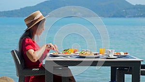 A young woman on vacation delights in her breakfast at a luxury resort