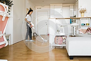 young woman vacuuming the fur of her pet. Cleaning concept.