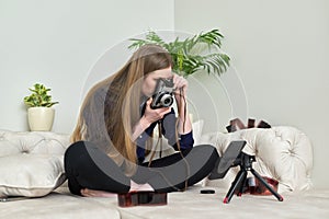 Young woman with vintage camera, photographic films, blogger recording stream