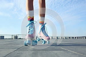 Young woman with vintage roller skates on sunny day, closeup view