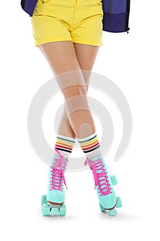 Young woman with vintage roller skates on white background
