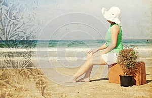 Young woman with vintage suitcase om the beach