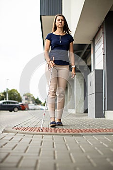 Young woman with vision impairment walking on city streets