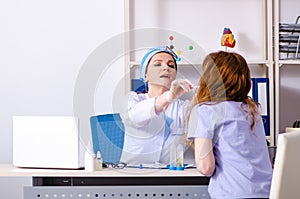 Young woman visiting female doctor otolaryngologist