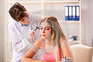 The young woman visiting female doctor otorhinolaryngologist photo