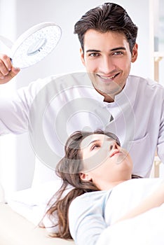 The young woman visiting male doctor cosmetologist